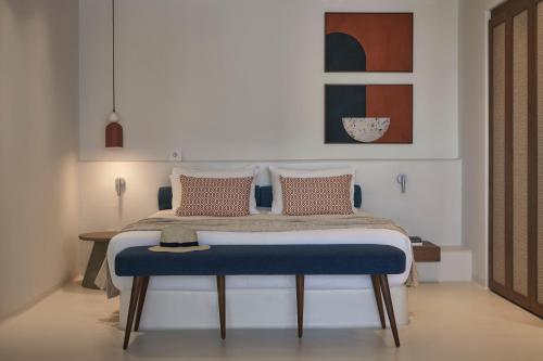 a bed with a blue bench in a room at Andronis Minois in Parasporos