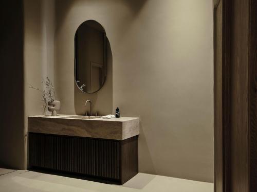 a bathroom with a sink and a mirror at Andronis Concept Wellness Resort in Imerovigli