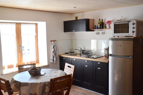une petite cuisine avec une table et un micro-ondes dans l'établissement Appartement dans chalet proche de la station de ski La Rosière San Bernardo, à Montvalezan