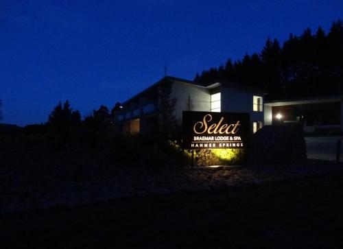 a building with a lit up sign at night at Braemar Lodge And Spa in Hanmer Springs