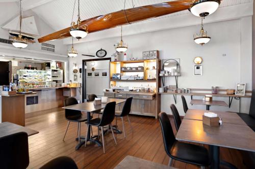 Un restaurante con mesas y sillas y una cocina. en Best Western Centralhotellet, en Västervik