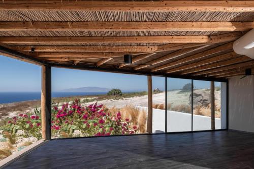 a room with a view of the ocean and flowers at Andronis Arcadia Hotel in Oia