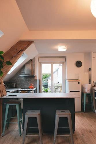 - une cuisine avec un comptoir et deux tabourets dans l'établissement Charming House with exceptional Loire view, à Bouchemaine