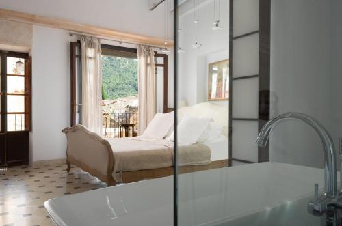 a bathroom with a tub and a bed and a window at Mallorca One in Pollença