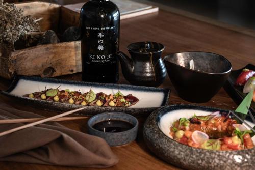 two dishes of food on a table with a bottle of wine at Andronis Arcadia Hotel in Oia