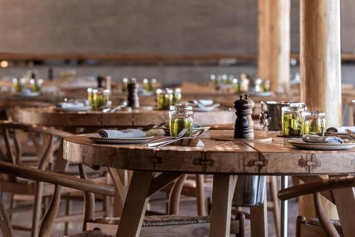 a group of wooden tables with plates and glasses on them at Andronis Arcadia Hotel in Oia