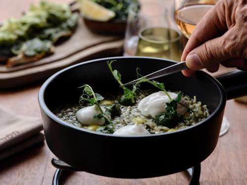 a person eating a bowl of food with eggs in it at Andronis Arcadia Hotel in Oia