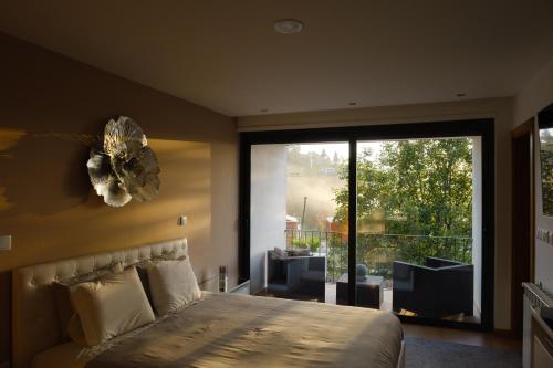 a bedroom with a large bed and a large window at Casa Horizontes de Arouca in Arouca