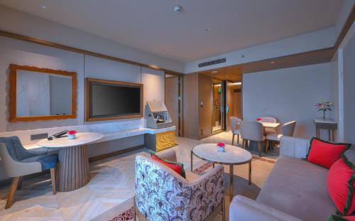 a hotel room with a couch and tables and a tv at Taj Agra in Agra
