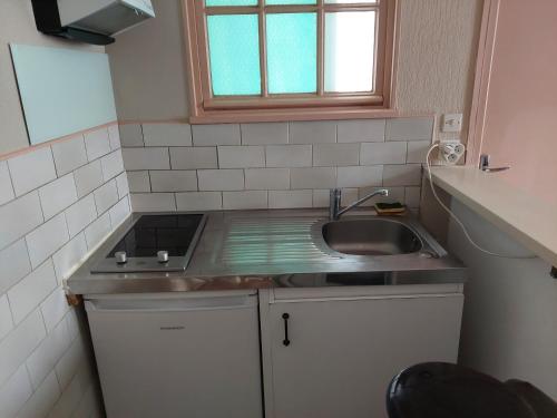 une petite cuisine avec un évier et une fenêtre dans l'établissement Joli appartement 3 pièces au centre de Trouville, à Trouville-sur-Mer