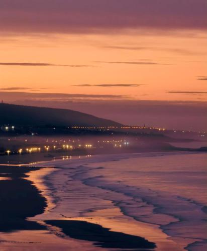 a view of the beach at night at Tazuri Surf House in Taghazout