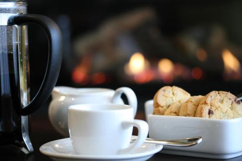 a table with cups of coffee and a plate of cookies at Braemar Lodge And Spa in Hanmer Springs