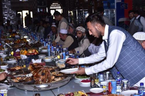a group of people eating food at a buffet at Kefayat Hotel in Balkh