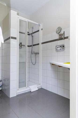 a bathroom with a shower and a sink at Hotel Nüller Hof in Wuppertal