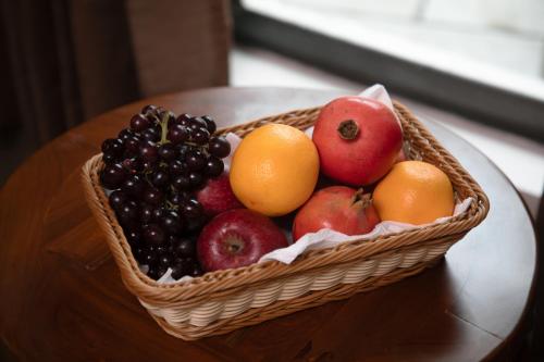 a basket of fruit sitting on a table at Apple Inn in Pollāchi