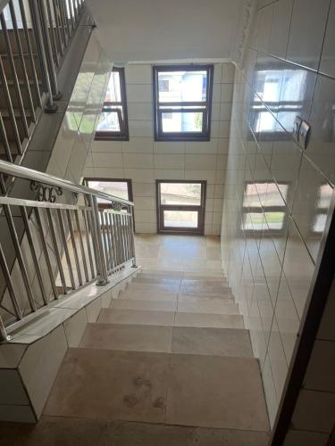 an empty hallway with stairs in a building with windows at Appartement Familial Confortable in Conakry