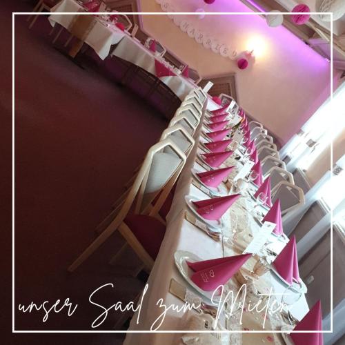 a long table with chairs and pink napkins on it at Marktbrauerei B&B - das Frühstückshotel in Bad Lobenstein in Bad Lobenstein