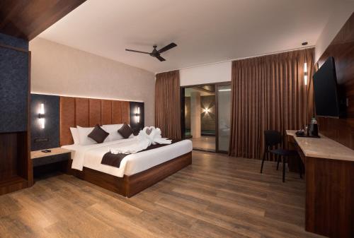 a hotel room with a bed and a desk and a table at Apple Inn in Pollāchi