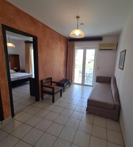 a living room with a couch and a bedroom at Corali Hotel in Tigaki