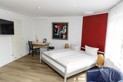 a bedroom with a white bed and a table at Hotel Nüller Hof in Wuppertal
