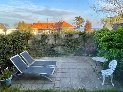 a patio with two chairs and a table and a fence at Rørvig Bed & Kitchen in Rørvig