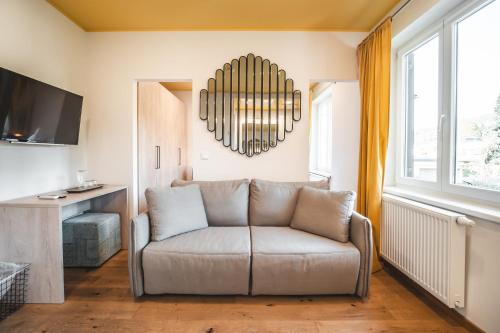 a living room with a couch and a chandelier at Boutiquehotel Caravella Velden by S4Y in Velden am Wörthersee