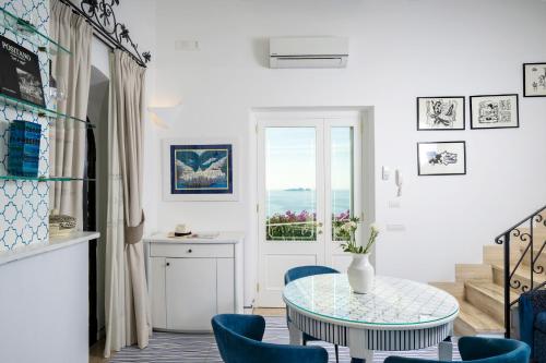 a room with a table and chairs and a window at Casetta Arienzo in Positano