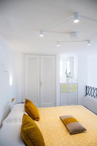 a bedroom with a bed with yellow pillows on it at Casetta Arienzo in Positano