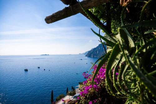 a view of the amalfi coast with purple flowers at Casetta Arienzo in Positano