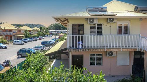 an apartment building with a balcony and a parking lot at Appartement Cayenne Chic Design Élégant en Bois Tropical in Cayenne