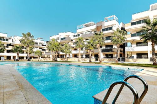 a swimming pool in front of a large apartment building at Sunrise new apartment with pool in Alicante