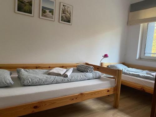 Un dormitorio con dos camas con toallas encima. en DWIE SOSNY Apartament 52, en Ustronie Morskie
