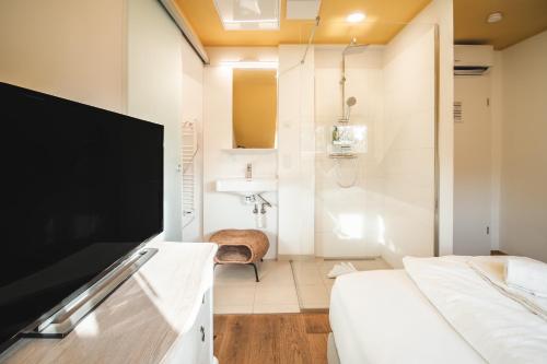 a room with two beds and a flat screen tv at Boutiquehotel Caravella Velden by S4Y in Velden am Wörthersee