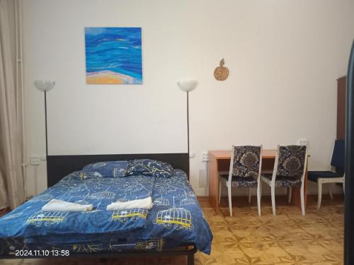 a bedroom with a bed and a table and chairs at Alabama in Kyiv