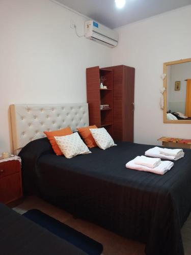 a bedroom with a large bed with towels on it at LOS GURISES Villa Elisa in Villa Elisa
