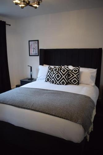 a bedroom with a large bed with a black headboard at The Little Luxury Getaway! in Moortown