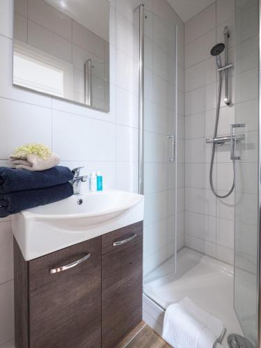 a bathroom with a white sink and a shower at Hosted by wendy Old city charming accommodation in Wassenaar