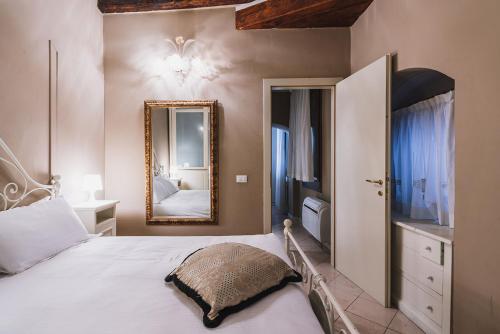 a bedroom with a large white bed with a mirror at Ca' Amadi in Venice