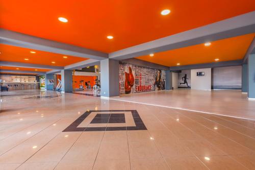 an empty lobby with an orange ceiling and a dance floor at Kipriotis Village Resort in Kos Town