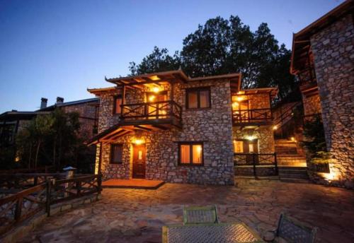 a stone house with lights on it at night at Hotel Complex Pierion Musses in Elatochori