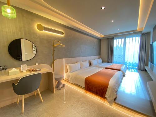 a bedroom with a bed and a desk and a mirror at MUMU Villa in Hengchun