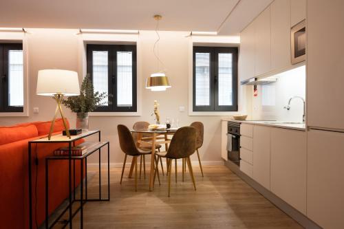 a kitchen and dining room with a table and chairs at Byobu Apartment, by Bolhão Residences in Porto
