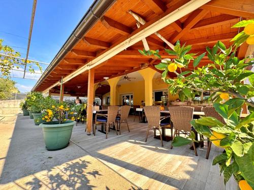 an outdoor patio with tables and chairs and plants at Apartments Neptun in Šilo