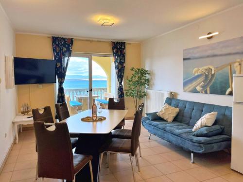 a living room with a table and a couch at Apartments Neptun in Šilo