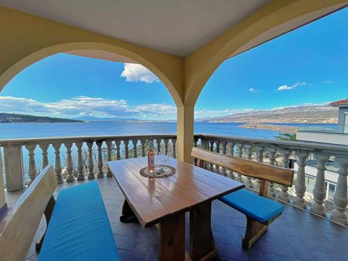 a table on a balcony with a view of the water at Apartments Neptun in Šilo