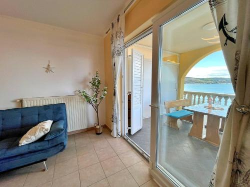 a living room with a blue couch and a balcony at Apartments Neptun in Šilo