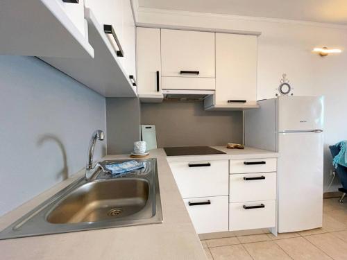 a kitchen with a sink and a refrigerator at Apartments Neptun in Šilo