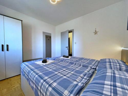 a bedroom with a bed with a blue plaid blanket at Apartments Neptun in Šilo