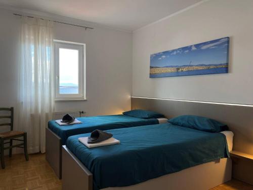 two beds in a hotel room with hats on them at Apartments Neptun in Šilo