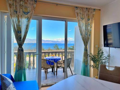 a dining room with a view of the ocean at Apartments Neptun in Šilo